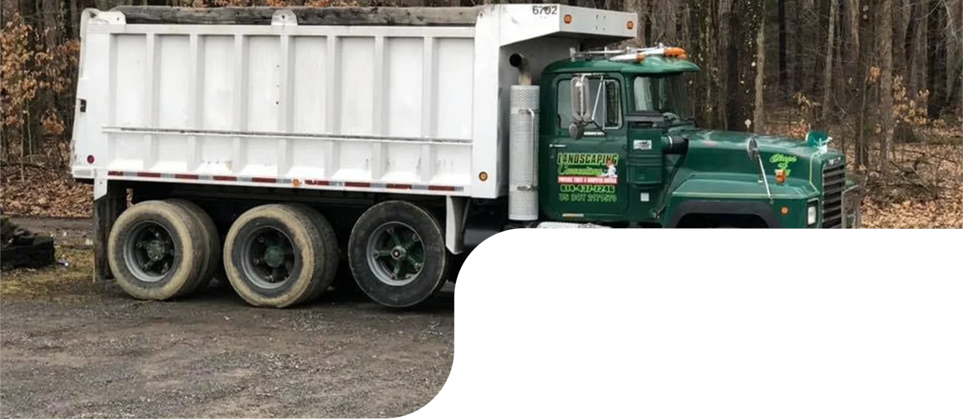Green dumpster truck parked outside